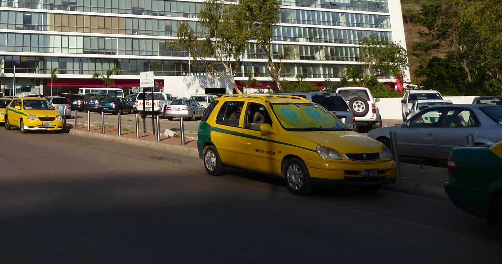 Táxis amarelos numa praça de táxis em Maputo